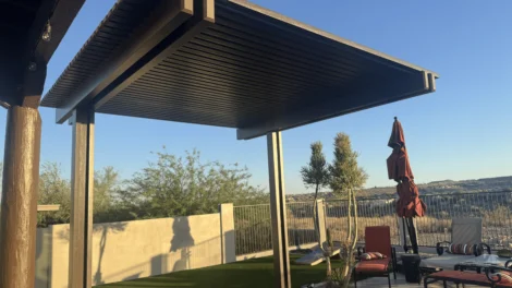 Modern metal pergola in a backyard patio area.